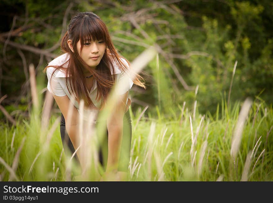 Young Thai woman seeking for something in the forest