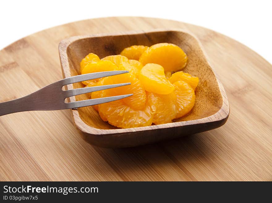 Tangerine peeled with fork and in the wooden bowl