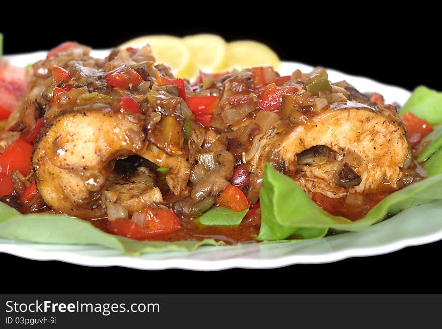 Baked fish on plate on black background