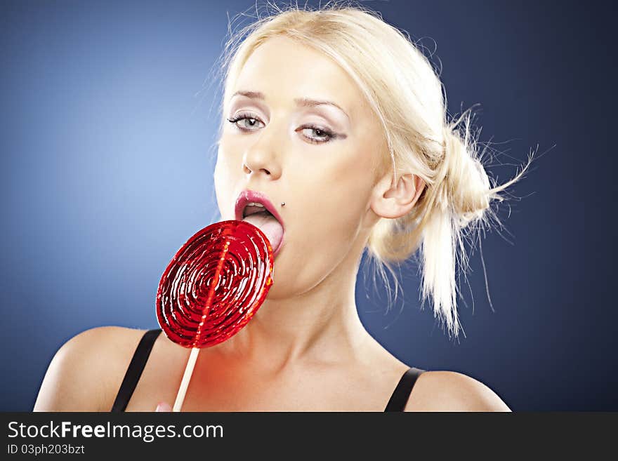 Beautiful model licks a lollipop.