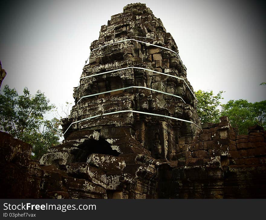 Banteay Kdei, a massive Buddhist monastery from the latter part of 12th century, is surrounded by four concentric wall. Picture show the central tower in a ruinous state and being tie up to prevent collapse. Banteay Kdei, a massive Buddhist monastery from the latter part of 12th century, is surrounded by four concentric wall. Picture show the central tower in a ruinous state and being tie up to prevent collapse.