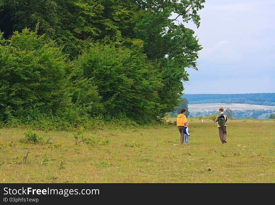 Mother and two sons in the green woods for a walk