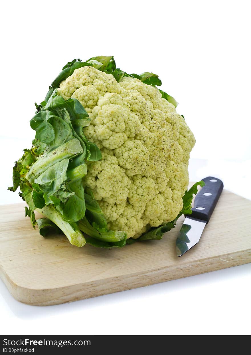 Cauliflower and knife on chopping board