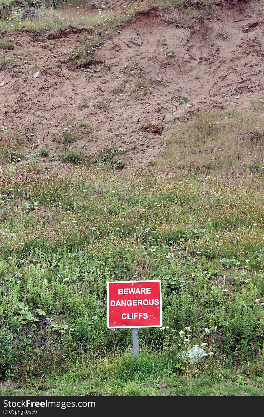 Red Danger Sign beware dangerous cliffs closeup