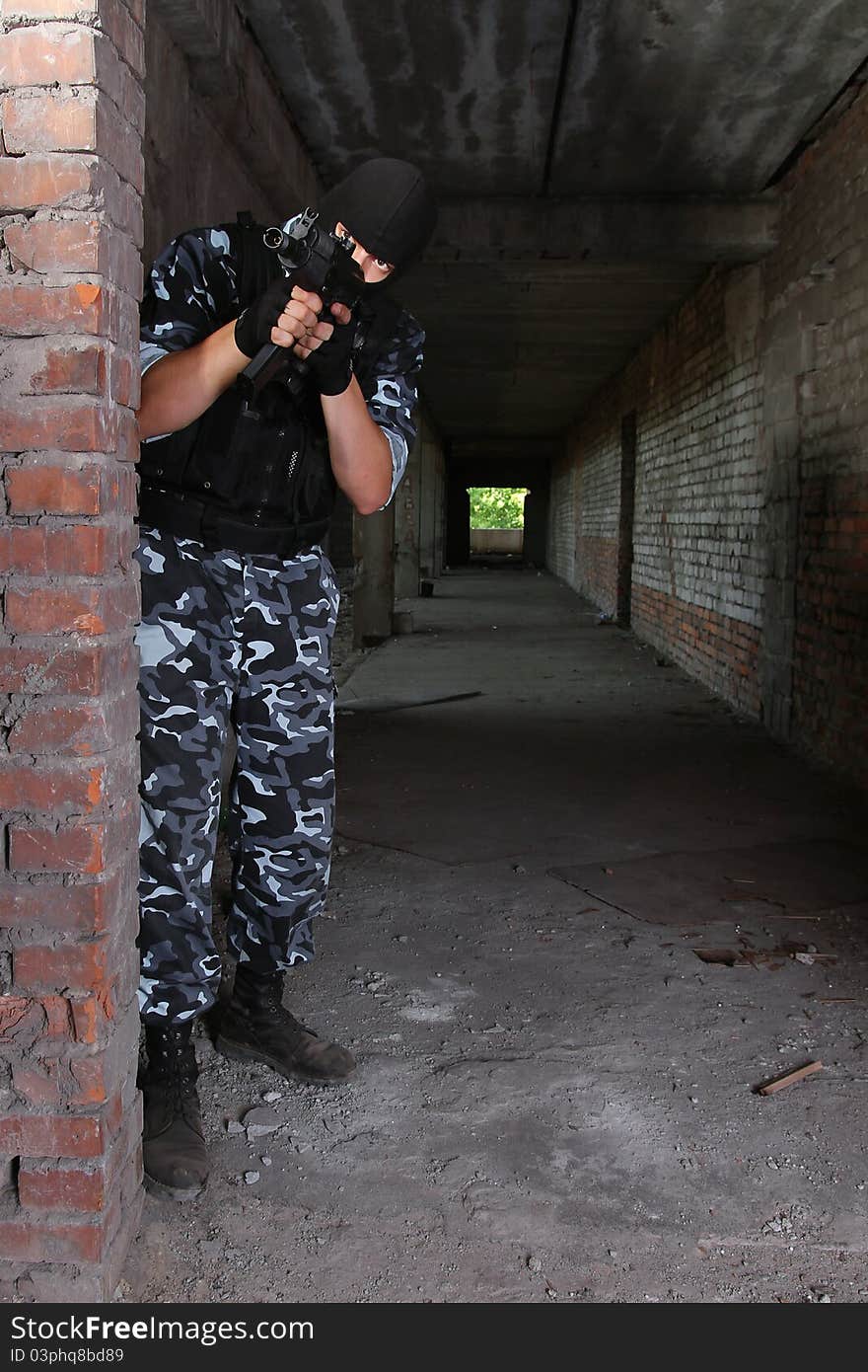 Armed soldier in black mask targeting with a gun