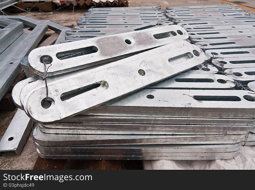 Metal flat brace in stockpile stack in group for use in electrical work. Metal flat brace in stockpile stack in group for use in electrical work