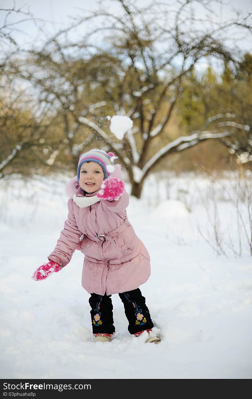 Little girl playing snowballs