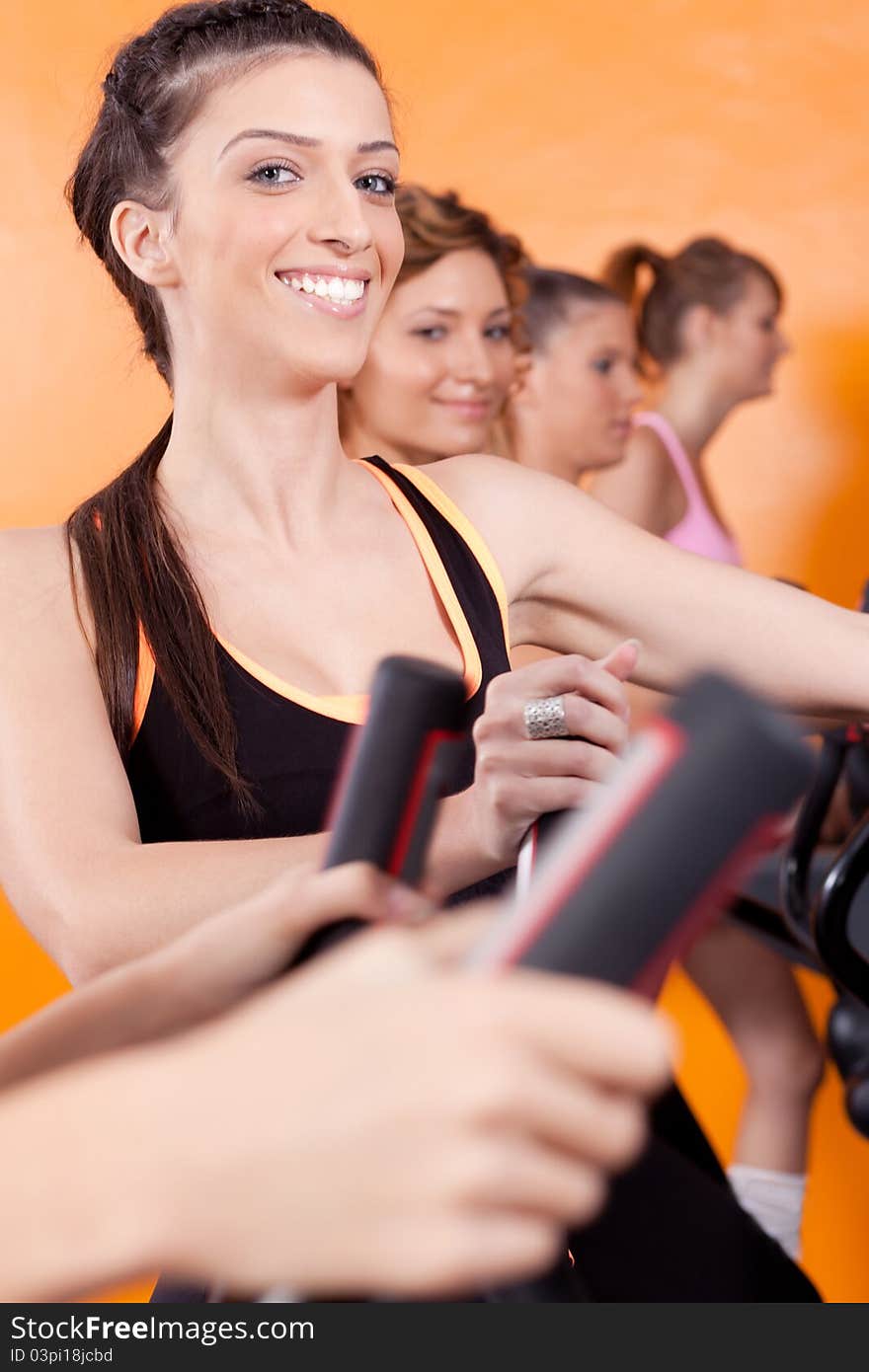 Group of four people in the gym, exercising their legs doing cardio training.