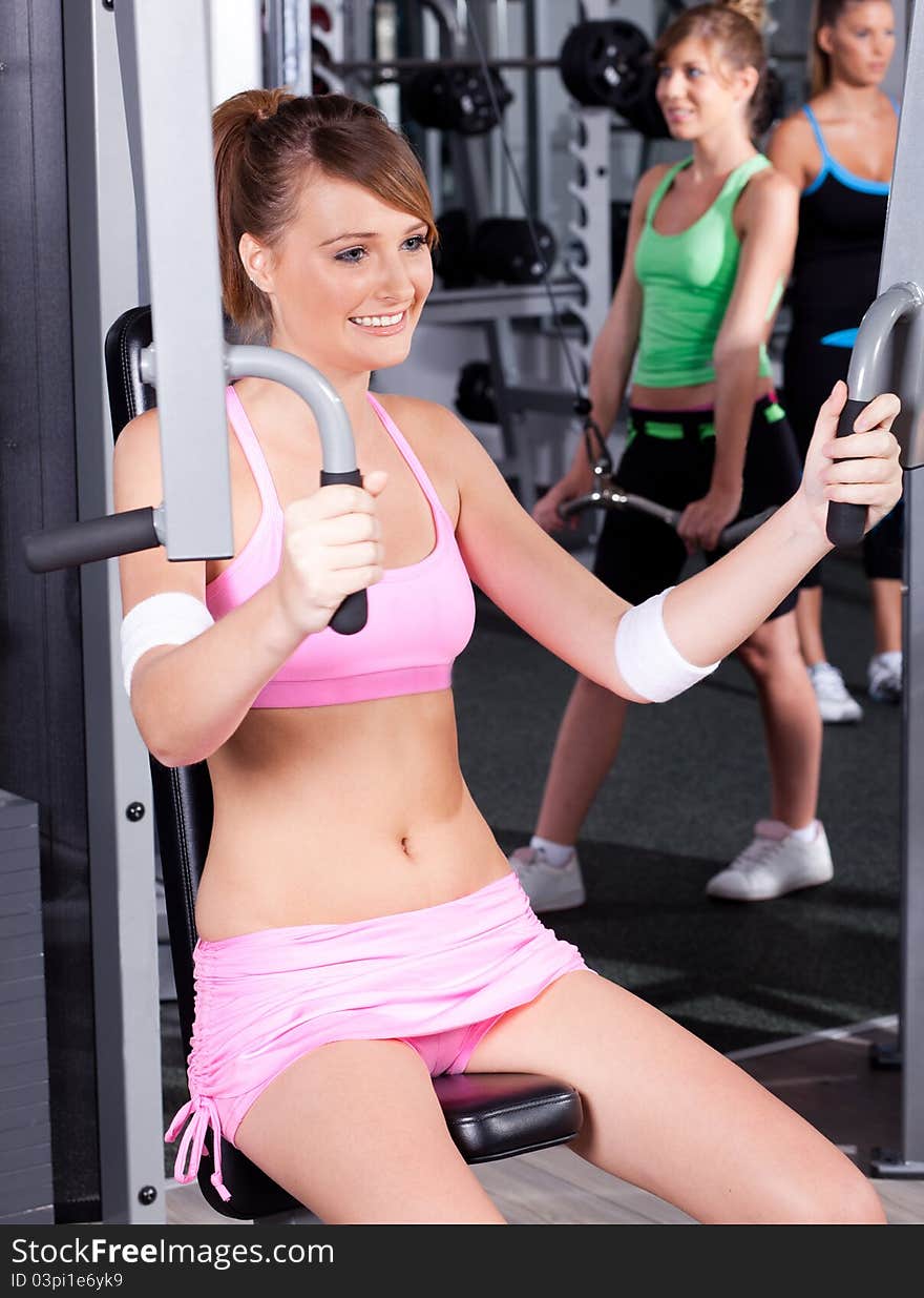 Portrait of young female exercising in gym...