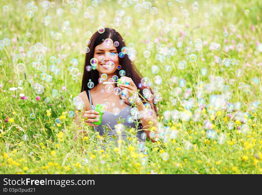 Happy woman smile in green grass soap bubbles around. Happy woman smile in green grass soap bubbles around