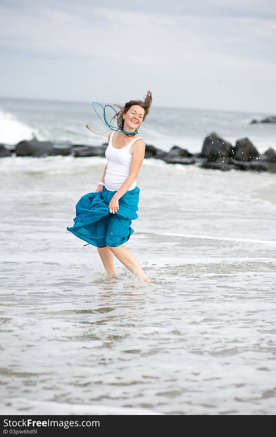 Beautiful young woman has fun on the ocean shore