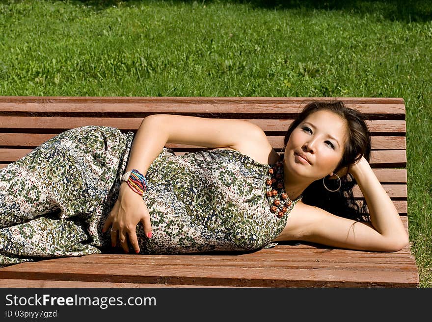 Beautiful pregnant girl lying on bench in park