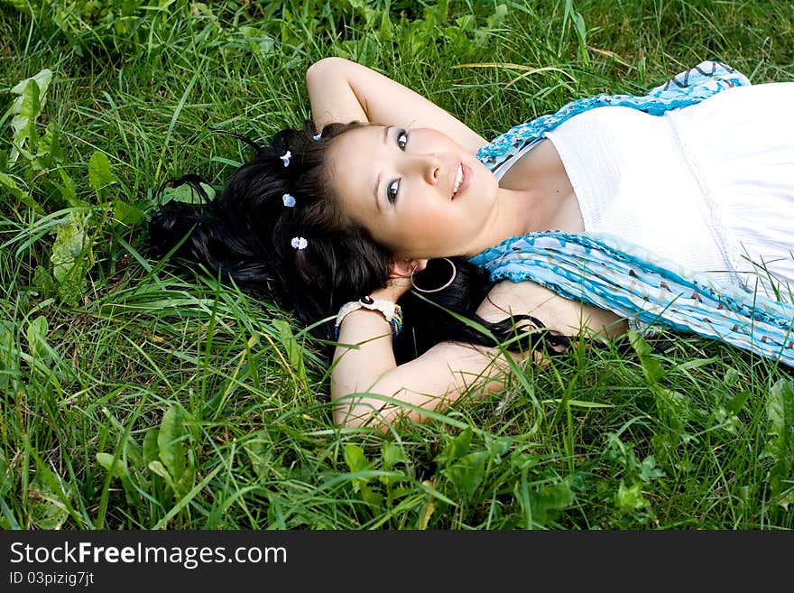 Beautiful pregnant girl lying on grass in park