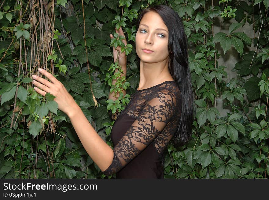 Beautiful young girl. Polish female model posing in garden, holding green branches and leaves. Beautiful young girl. Polish female model posing in garden, holding green branches and leaves.