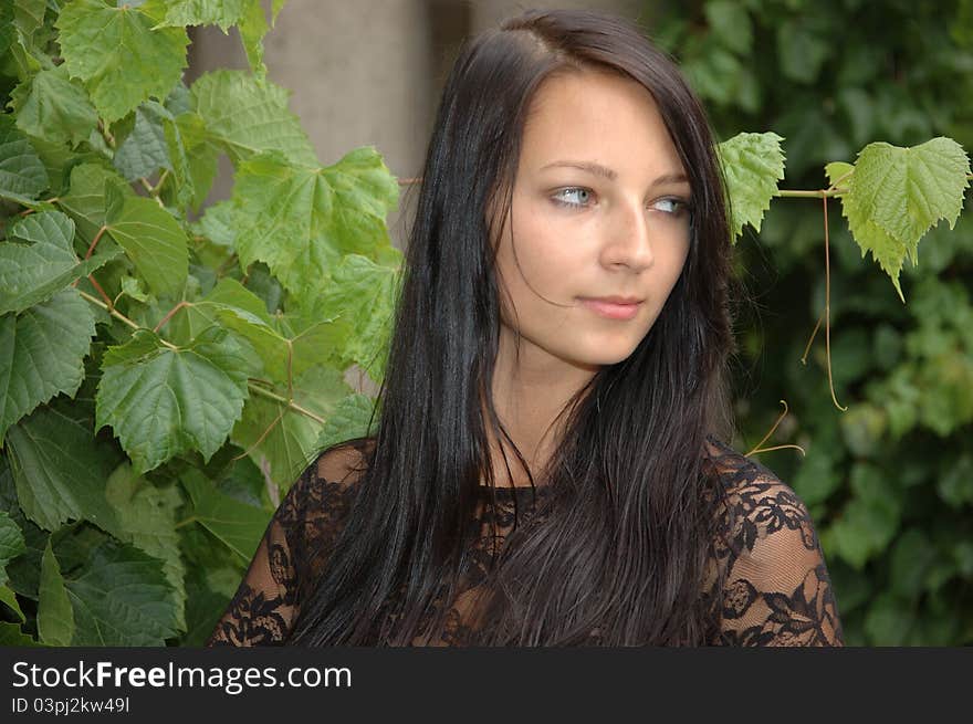 Charming female model from Poland. Young girl posing in garden with green leaves as background. Charming female model from Poland. Young girl posing in garden with green leaves as background.