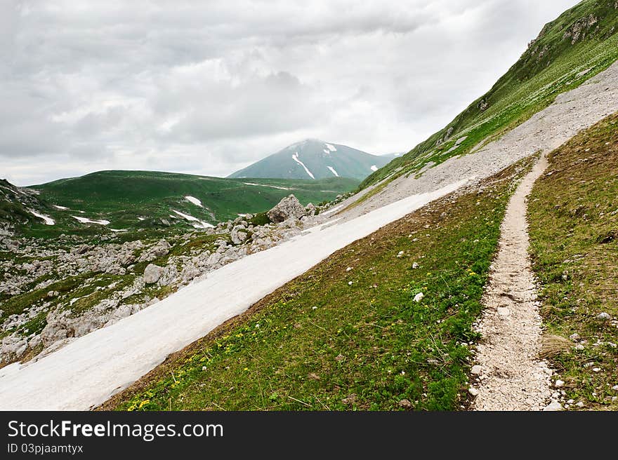 Snow and grass in the North Caucasus mountains. Russia.