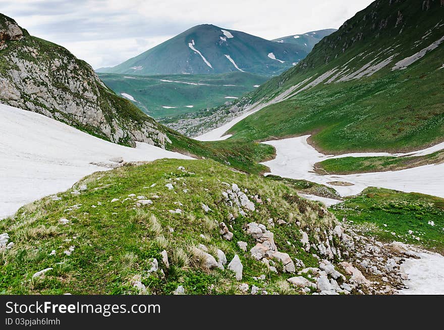 Snow and grass in the North Caucasus mountains. Russia.