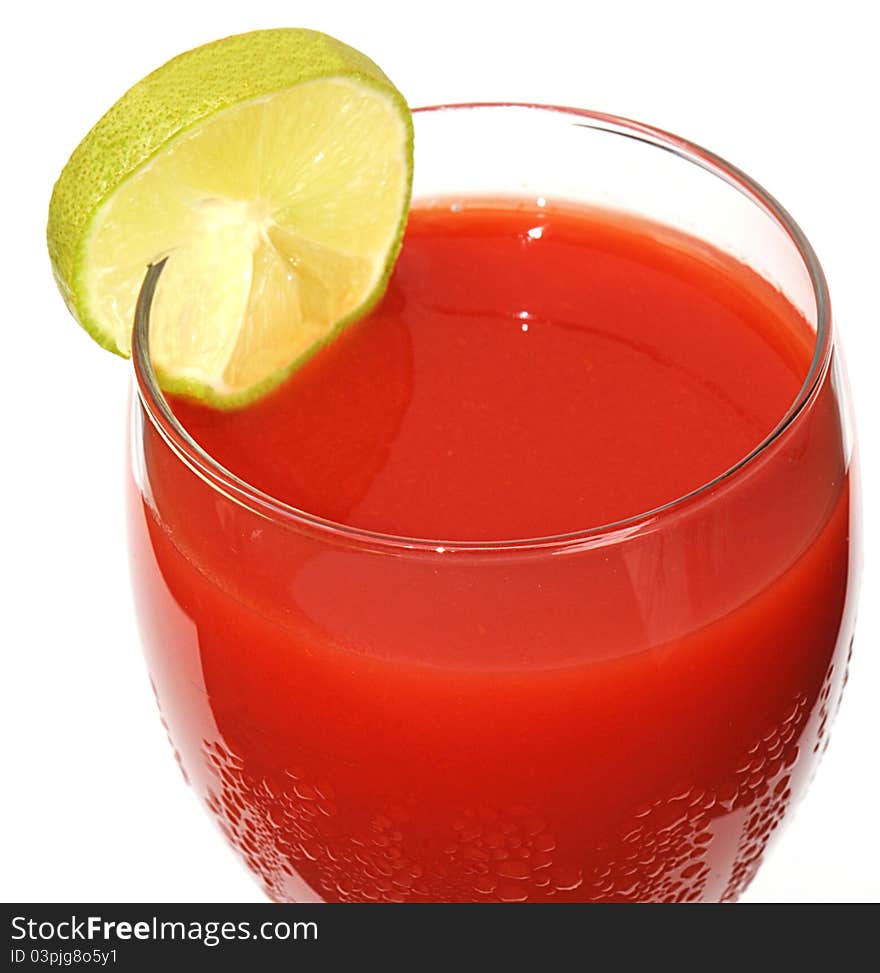 Closeup of a glass of cold tomato juice with a slice of lime and condensation droplets on glass. Closeup of a glass of cold tomato juice with a slice of lime and condensation droplets on glass.