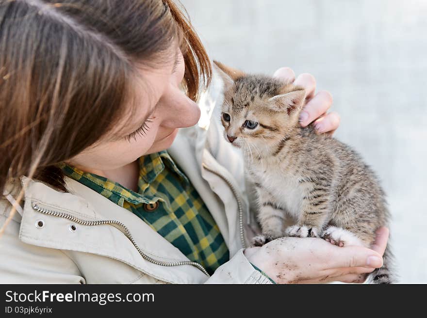 Young girl hugging a small kitten