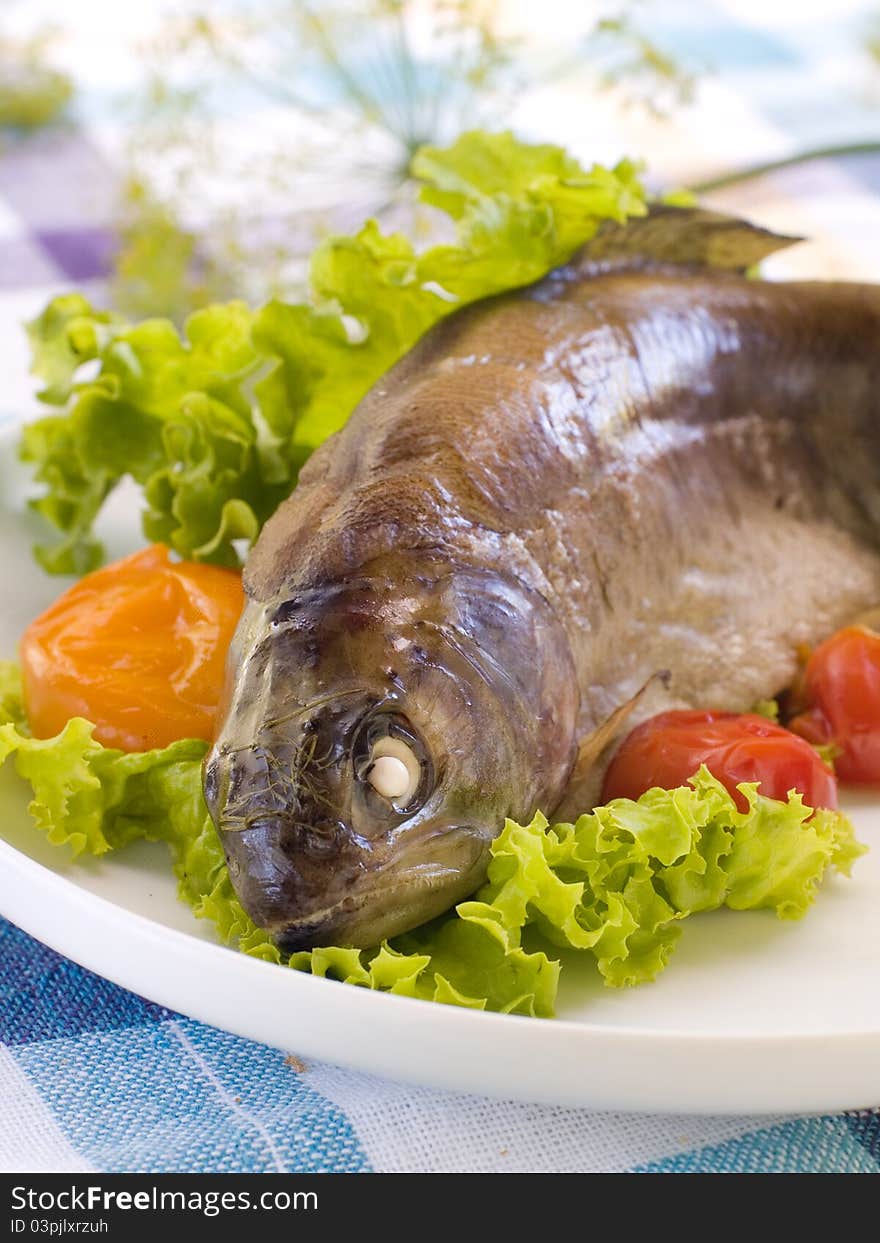 Grilled fish with lettuce and tomatoes. Selective focus