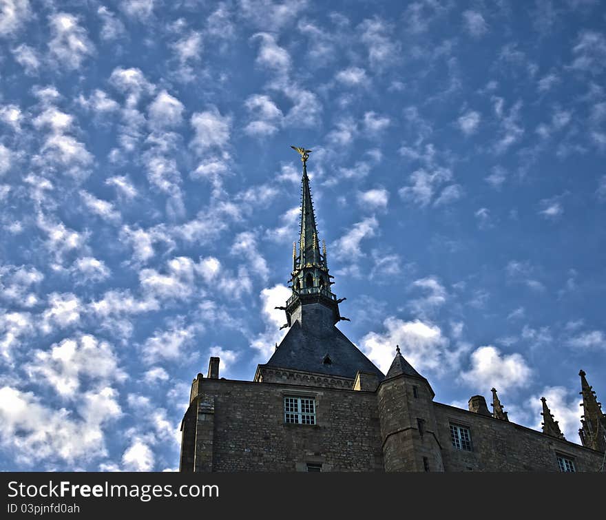 Golden statue of st. michel at mont saint michel abbey on a blue sky background. Golden statue of st. michel at mont saint michel abbey on a blue sky background