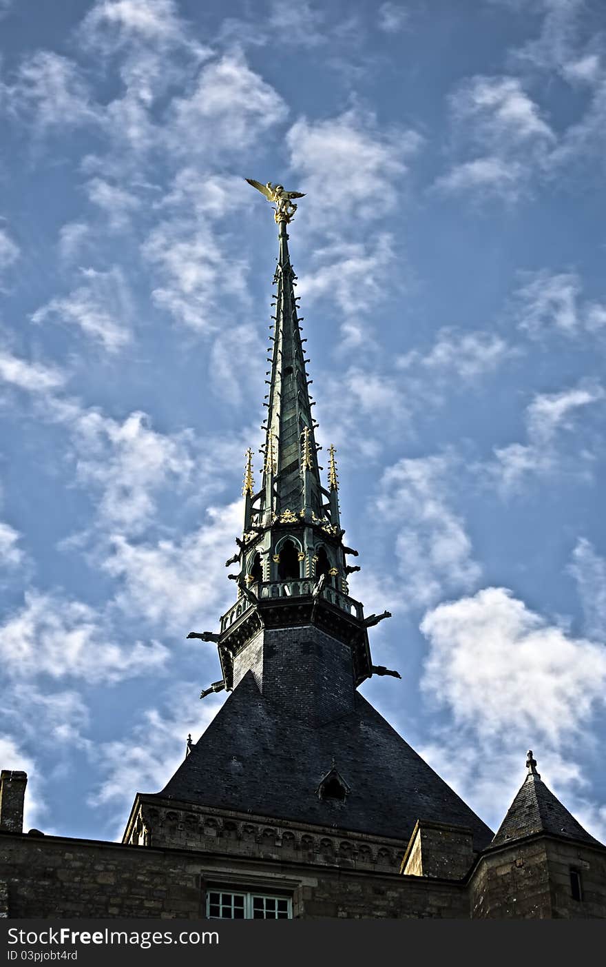 Golden statue of st. michel at mont saint michel abbey on a blue sky background. Golden statue of st. michel at mont saint michel abbey on a blue sky background