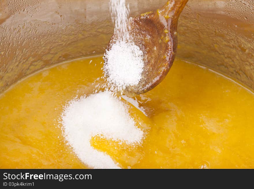 Studio-shot of cooking and preparing homemade small yellow plum ( mellow mirabelle ) jam in a pot. with sugar falling inside the pot. Studio-shot of cooking and preparing homemade small yellow plum ( mellow mirabelle ) jam in a pot. with sugar falling inside the pot.