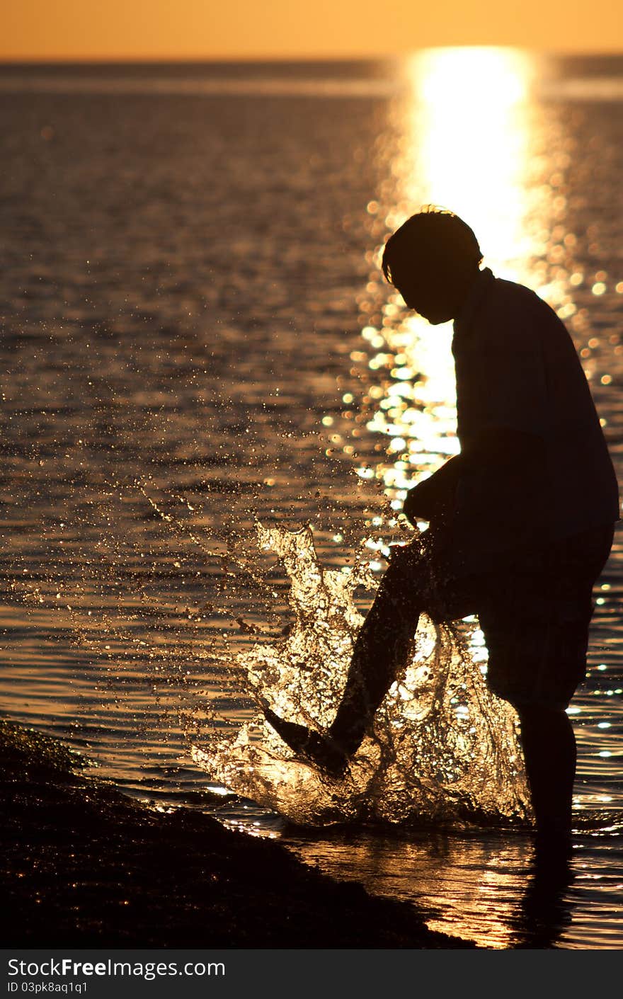 Silhouette the guy at sunset, guy plays lake, Beautiful decline on lake. Silhouette the guy at sunset, guy plays lake, Beautiful decline on lake