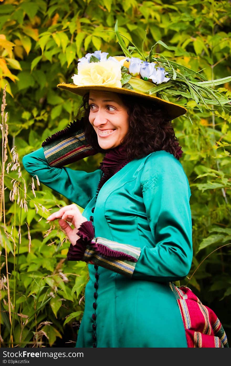 A beautiful woman in a green vintage dress and yellow hat