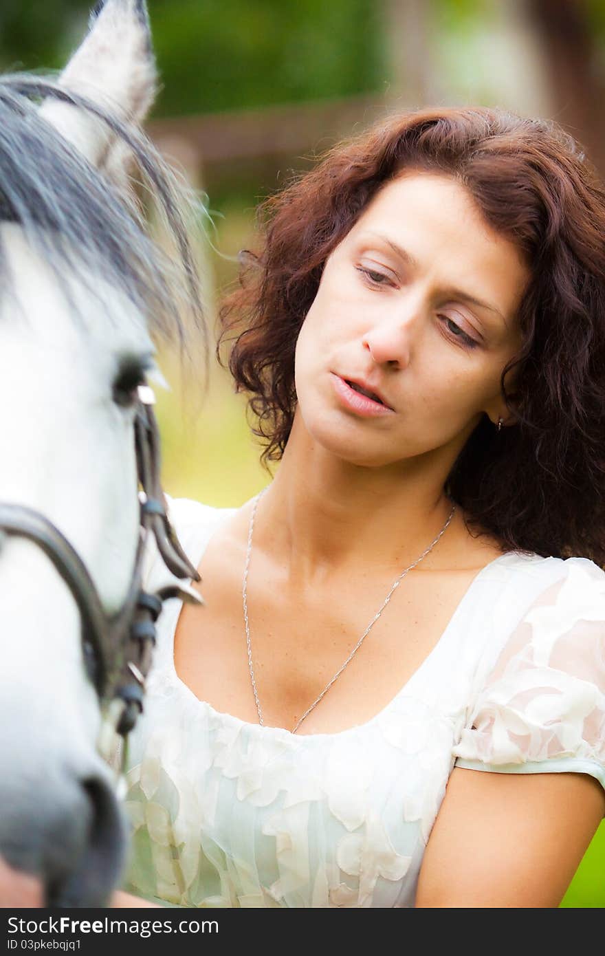 Beautiful woman in white with a horse