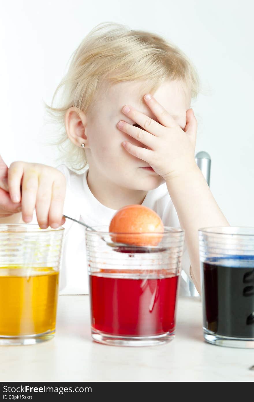 Little girl during Easter eggs' coloration