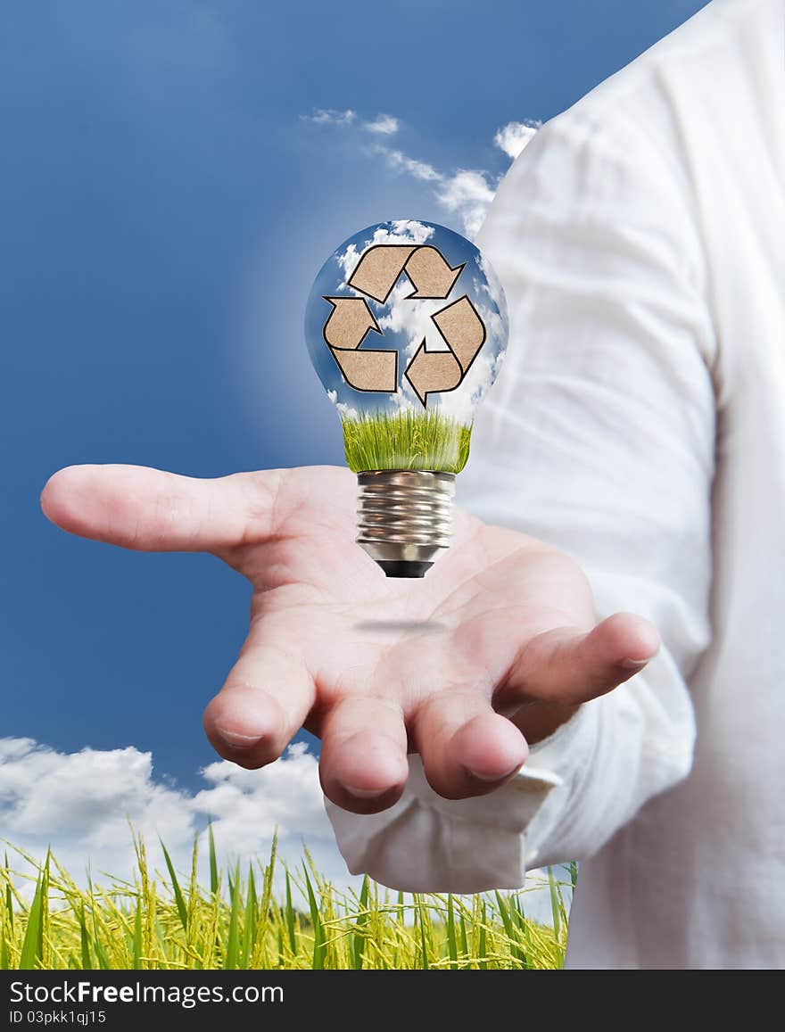 Recycle sign in a light bulb with blue sky