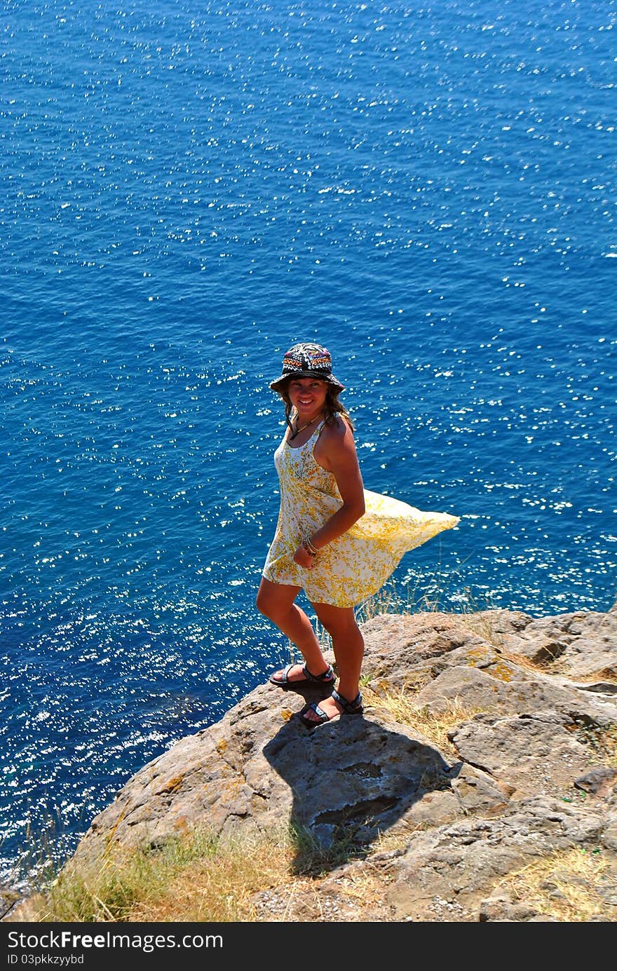 A woman standing on a rock at the sea. A woman standing on a rock at the sea