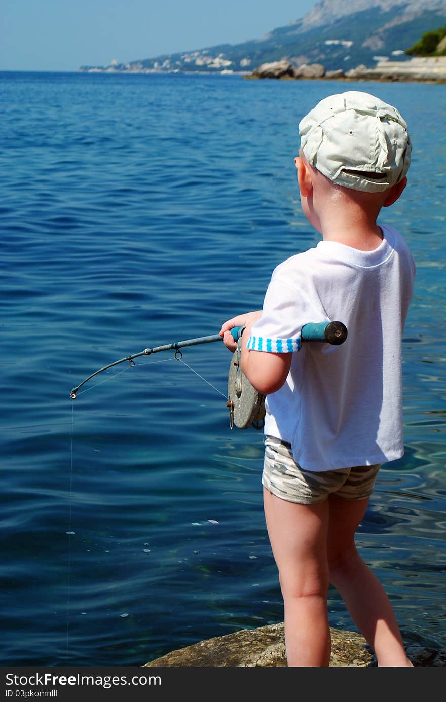 Boy is standing on dock with fishing rod. Boy is standing on dock with fishing rod