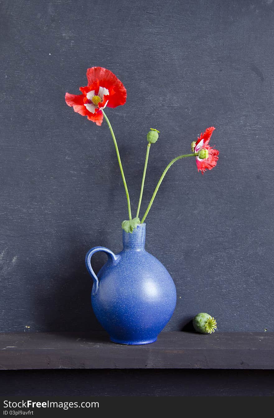 Blue vase and poppy blossoms