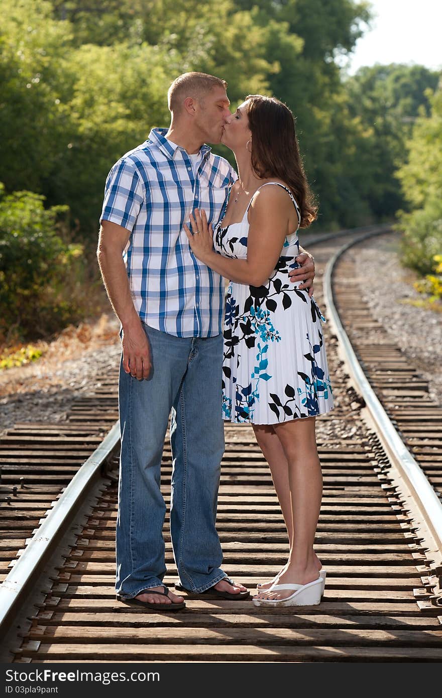 Attractive couple kissing on railroad tracks. Attractive couple kissing on railroad tracks