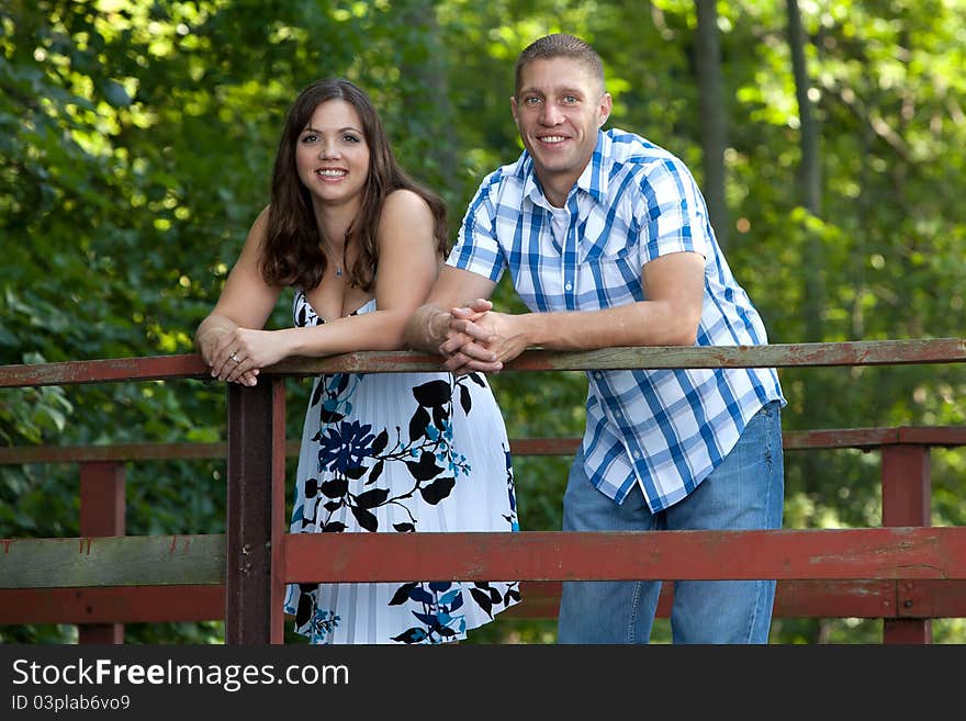 Smiling happy couple on bridge in forest