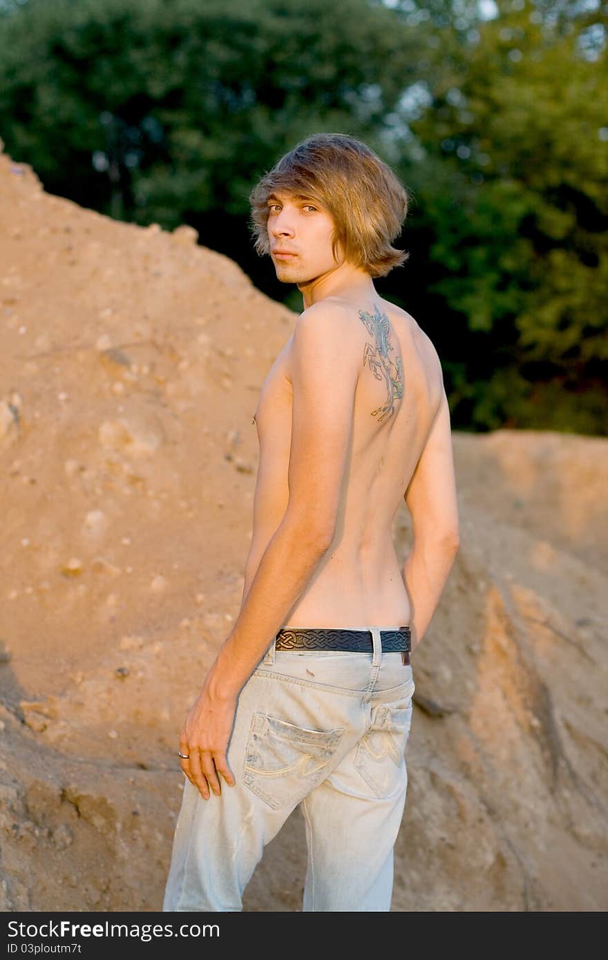 Handsome man walking near sand