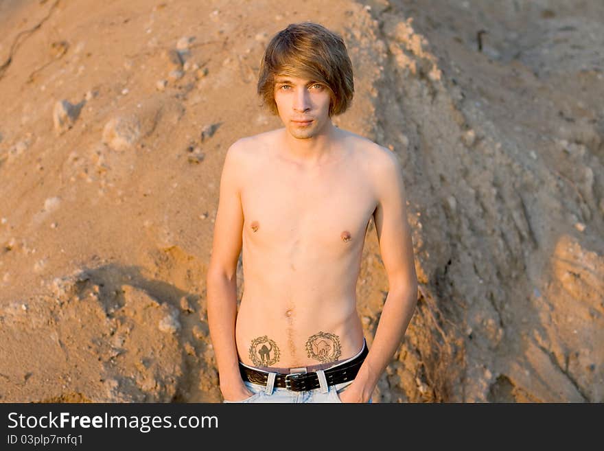 Sexy man walking near sand