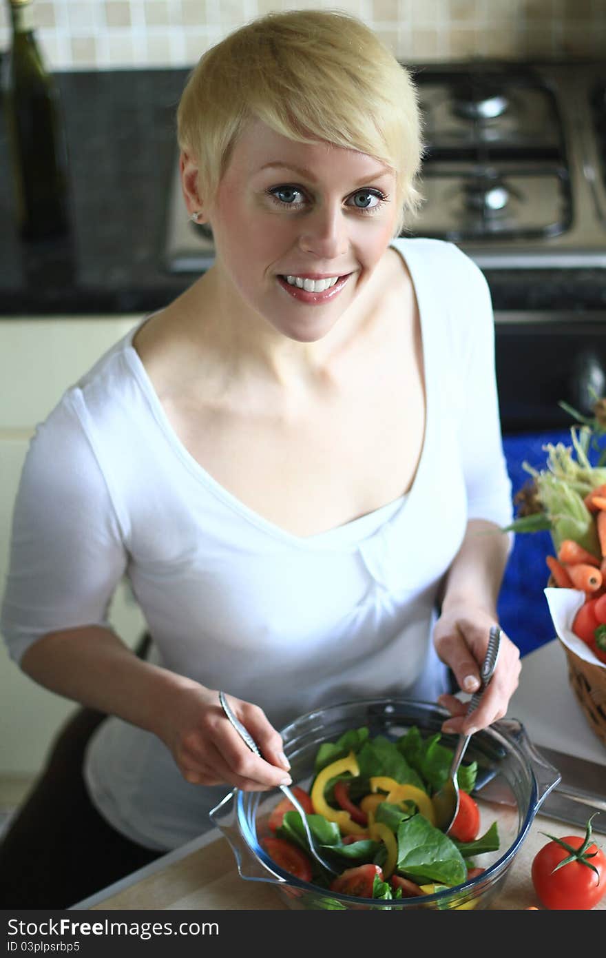 Image of a woman preparing salad in the Kitchen