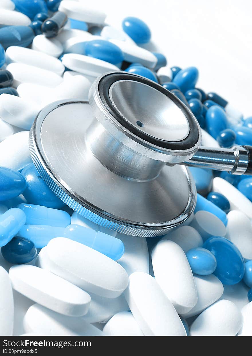 Stethoscope and colored pills,white and blue pills. Stethoscope and colored pills,white and blue pills