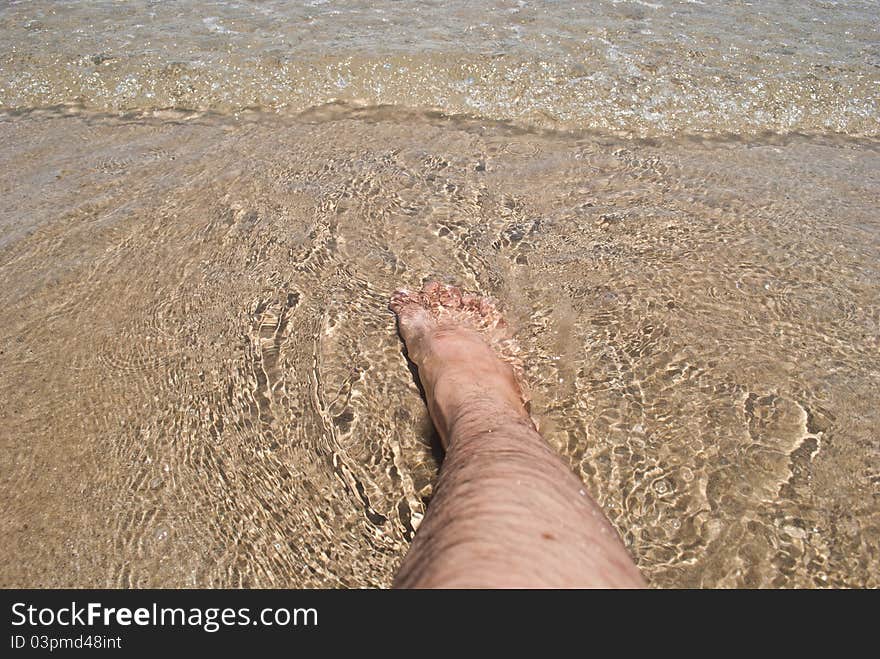 Foot in water on Rayong beach of thailand.