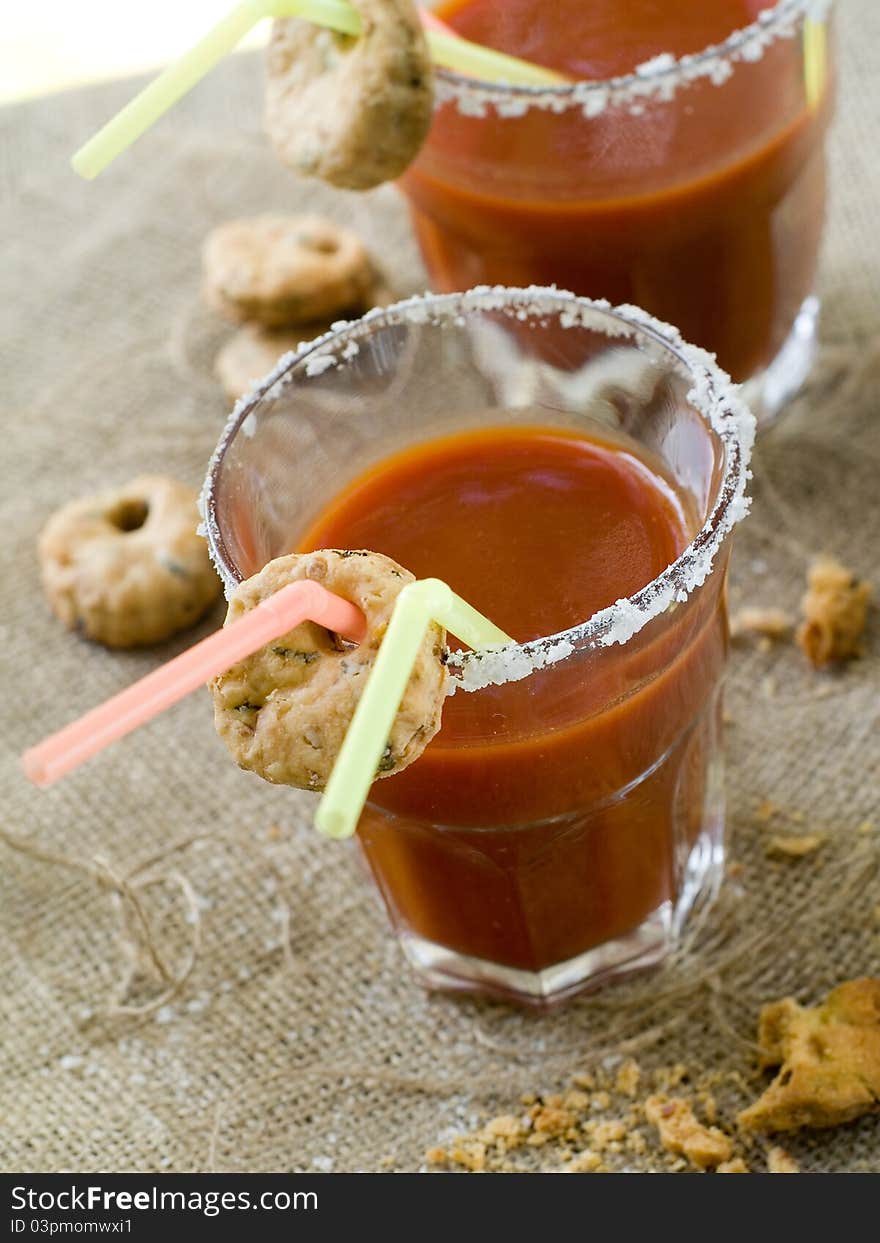 Bloody Mary or tomato juice with cookies and straw. Selective focus