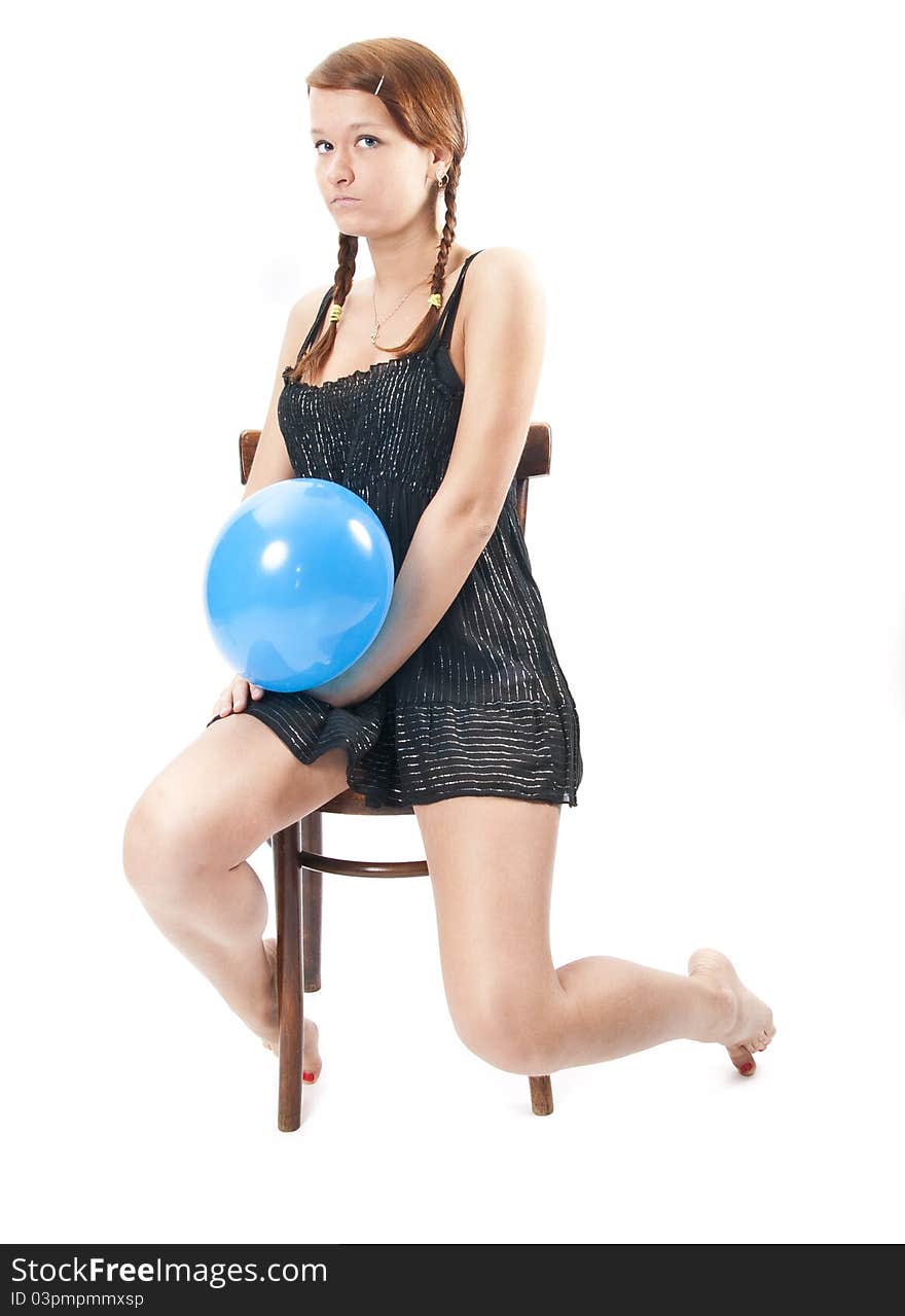 Young smart brunette in little black dress on the chair with blue balloon. Isolated over white