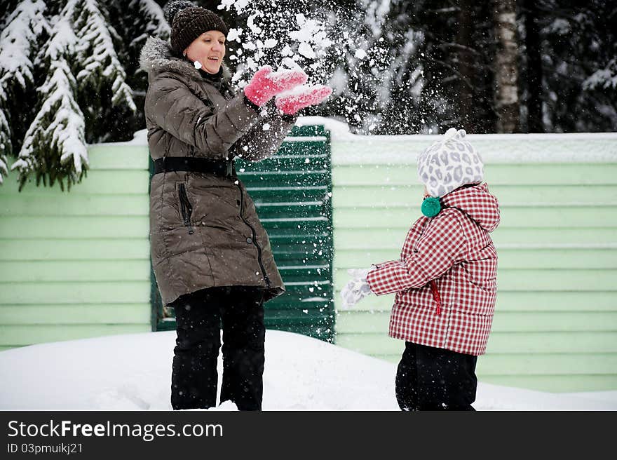 Young mother and daughter have fun in the snow