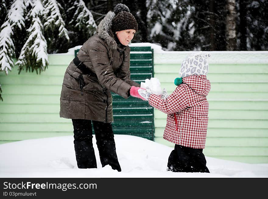 Young mother and daughter have fun in the snow