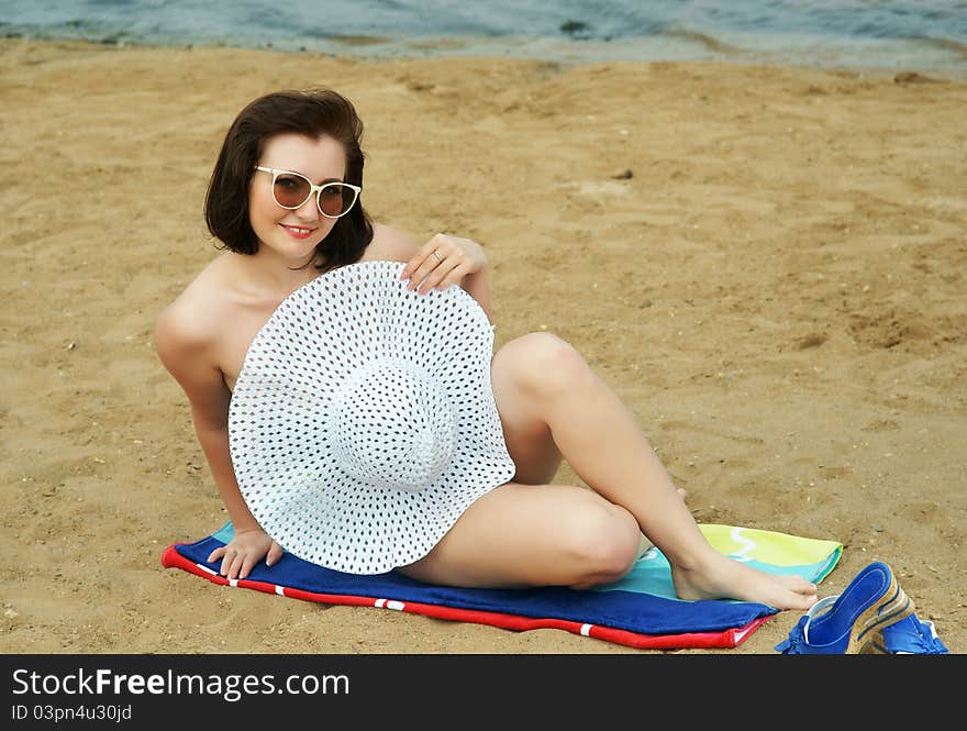 The girl on a beach in a white hat.