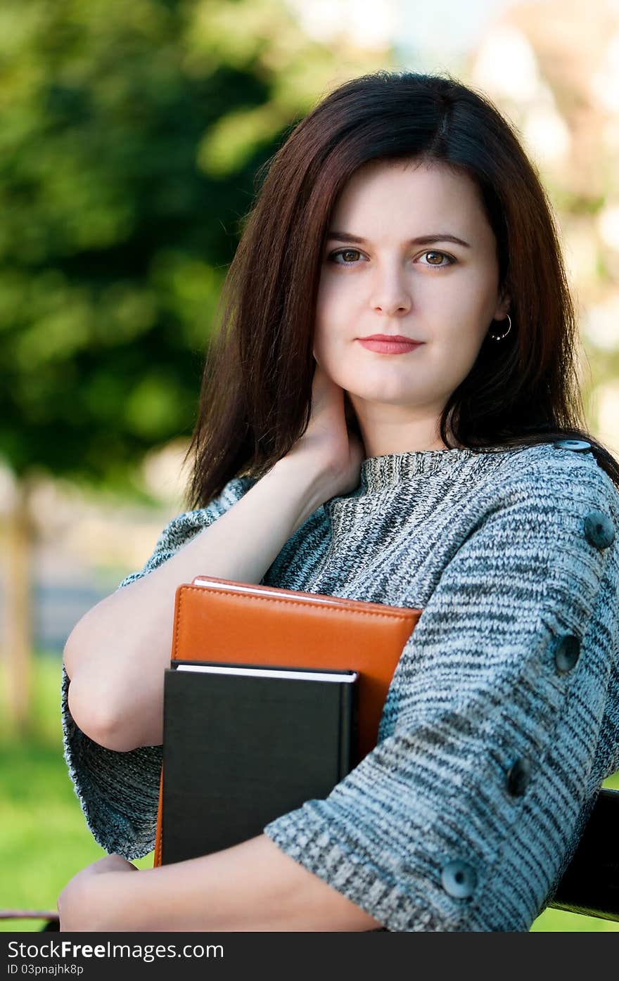 Portrait of a young female student with books at the campus