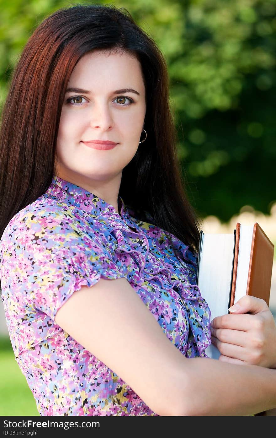 Portrait of a young female student with books at the campus