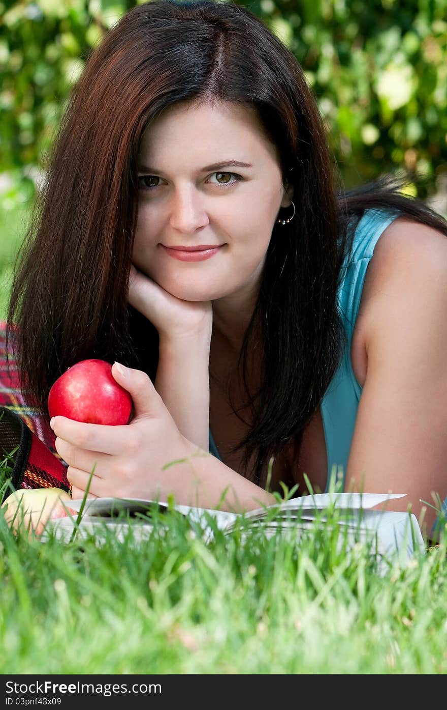 Portrait of a young female student with book at the campus